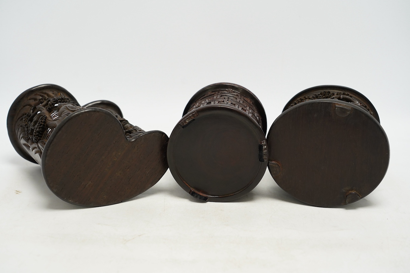 Two finely carved Chinese bamboo brush pots, and a reticulated hardwood brushpot, largest 14.5cm high. Condition - bamboo pots with cracks